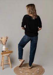 Pull léopard en maille fine porté par une femme, vue de dos, jean, tabouret