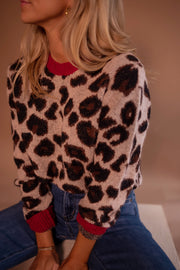 Pull doux à motif léopard porté par une femme, vue rapprochée, col rouge, motif léopard