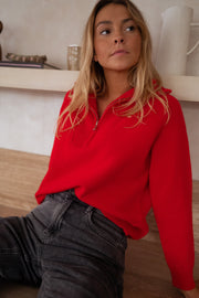 Pull rayé col montant zippé porté par une femme, vue de trois-quarts, regard au loin