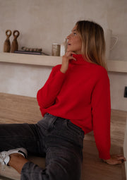 Pull rayé col montant zippé porté par une femme, assise, de profil