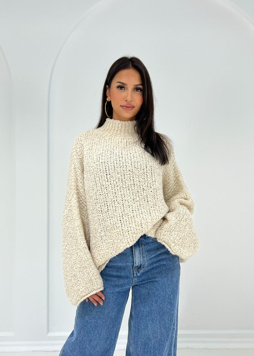 Pull bouclé beige — vue portée de face, plan moyen, col montant