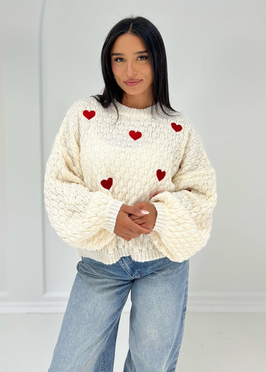 Pull blanc crème motif cœurs — vue portée de face, petits cœurs rouges brodés, manches ballon, jean clair