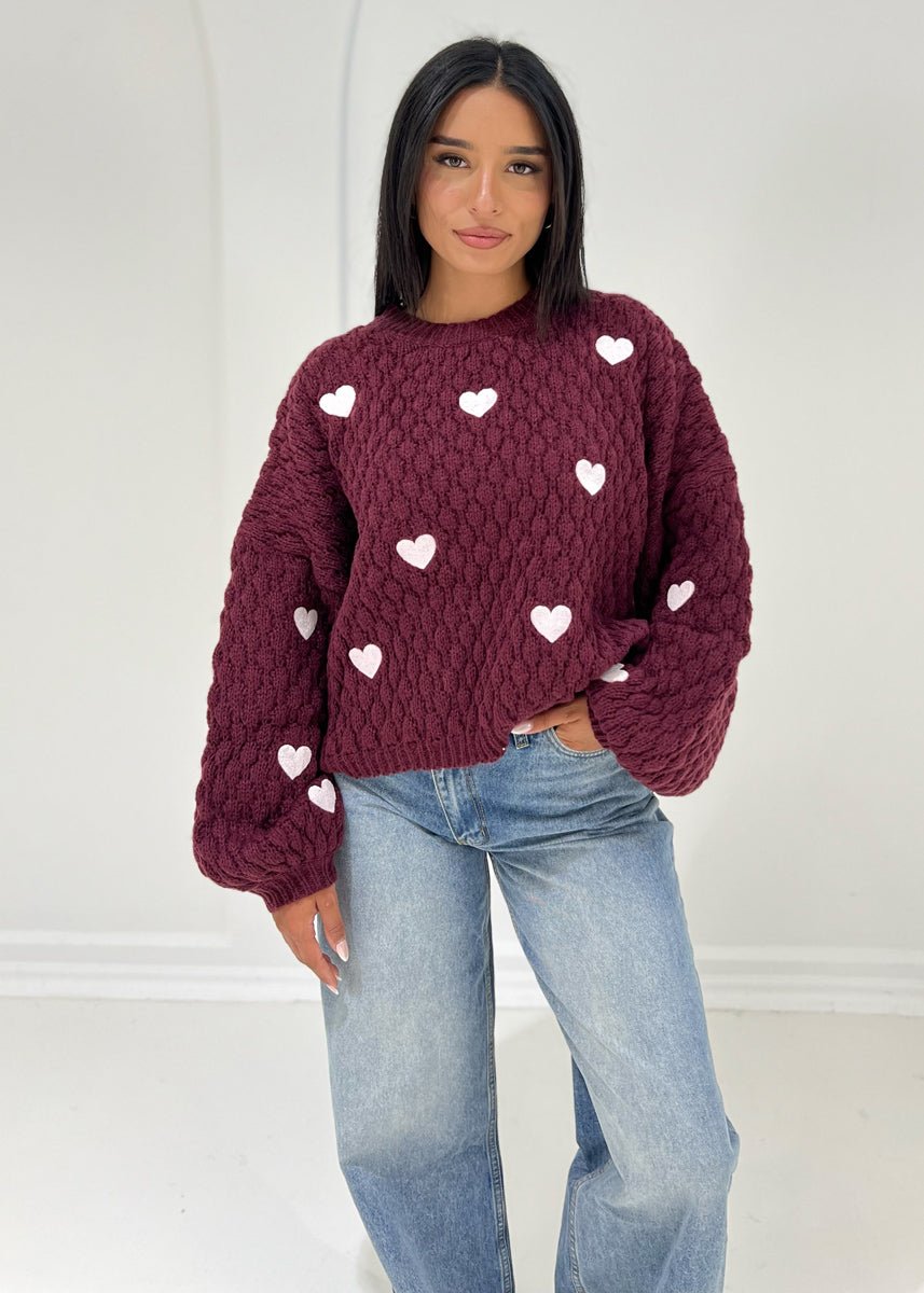 Pull bordeaux à motif cœurs — vue portée de face, rentré dans un jean clair large