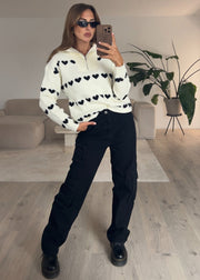 Pull à fermeture zippée crème — selfie au miroir, vue portée en pied, cœurs noirs, lunettes de soleil