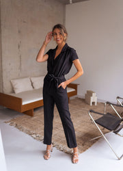 Combinaison fluide à col chemise portée par une femme, vue de face, canapé, tapis