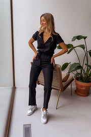 Combinaison fluide à col chemise portée par une femme, vue de trois-quarts, chaise pliante, baskets blanches