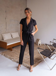 Combinaison fluide à col chemise portée par une femme, vue de face, canapé, ceinture nouée