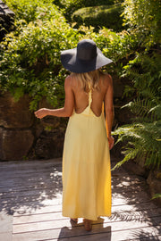 Robe longue à dos ouvert portée par une femme, vue de dos, chapeau noir, dos ouvert