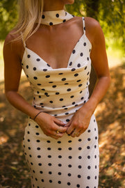 Robe à pois effet soie portée par une femme, vue rapprochée, foulard, bretelles fines