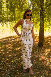 Robe à pois effet soie portée par une femme, vue de face, lunettes, mains sur les hanches