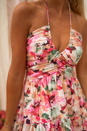 Robe fleurie courte décolleté V portée par une femme, vue rapprochée, col licou, imprimé fleuri