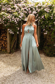 Robe à col montant fleuri portée par une femme, vue de face, jardin fleuri, jupe longue