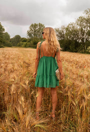 Robe courte cache-cœur fluide portée par une femme, vue de dos, épis, cheveux blonds