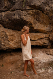 Robe en tweed à sequins portée par une femme, vue de profil, rochers, de profil