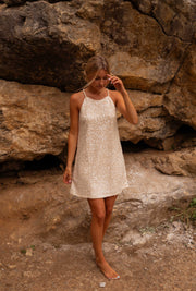 Robe en tweed à sequins portée par une femme, vue de face, rocher, pieds nus