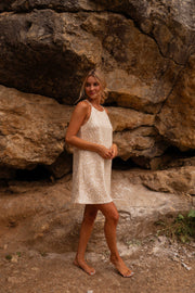 Robe en tweed à sequins portée par une femme, vue de face, rocher, bras le long du corps
