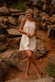 Robe en tweed à sequins portée par une femme, vue de face, rochers, sourire