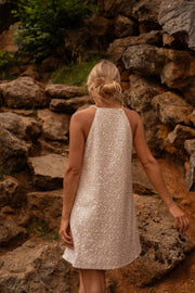 Robe en tweed à sequins portée par une femme, vue de dos, rochers, escalier de pierre