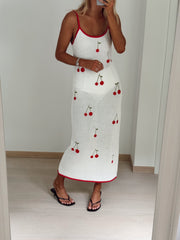 Robe crochet à cerises brodées portée par une femme, vue de face, sandales noires, parquet