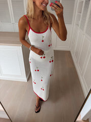 Robe crochet à cerises brodées portée par une femme, vue de trois-quarts, téléphone, cheveux blonds