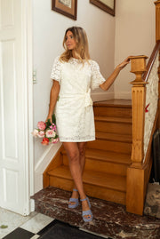 Robe brodée à col rond portée par une femme, en marchant, escalier, bouquet