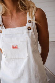 Robe salopette à poche portée par une femme, vue rapprochée, poche, boutons en bois