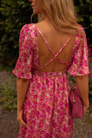 Robe fleurie à dos ouvert portée par une femme, vue rapprochée, dos ouvert, bretelles croisées