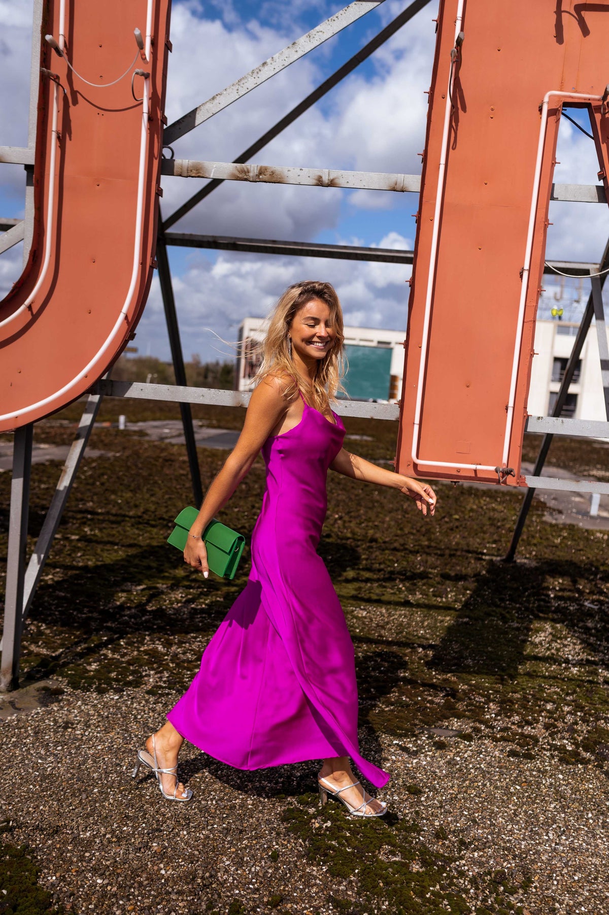 Robe fluide légèrement moulante portée par une femme, en marchant, enseigne, sac vert