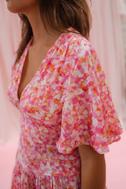 Robe fleurie à manches courtes portée par une femme, vue rapprochée, décolleté, manche