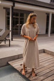 Robe éponge à manches courtes portée par une femme, vue de trois-quarts, cheveux blonds, ponton