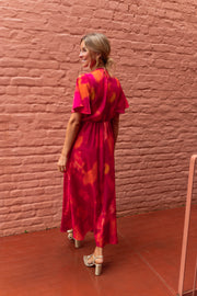 Robe longue col V fendue portée par une femme, vue de dos, briques, manches papillon