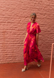 Robe longue col V fendue portée par une femme, en marchant, briques, sandales