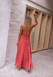 Robe longue évasée fluide portée par une femme, vue de dos, mur blanc, dos nu