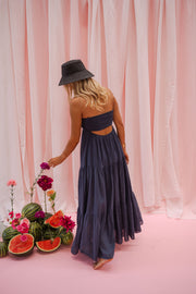 Robe longue à décolleté noué portée par une femme, vue de dos, chapeau noir, dos ouvert