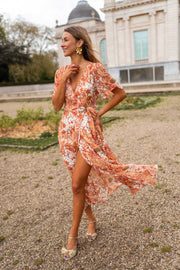Robe longue portefeuille fleurie portée par une femme, vue de face, jardin, jupe en mouvement