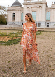 Robe longue portefeuille fleurie portée par une femme, vue de face, jardin, jupe portefeuille