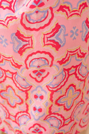 Robe courte imprimée dos nu portée par une femme, vue rapprochée, imprimé géométrique rose et rouge