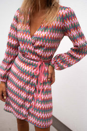 Robe manches longues cache-cœur portée par une femme, vue rapprochée, décolleté V, manches longues