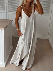 Robe en lin col V portée par une femme, silhouette entière, plan de travail, main sur la hanche