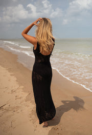 Robe crochet longue dos ouvert portée par une femme, vue de dos, plage, main dans les cheveux