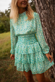 Robe fluide à motifs argentés portée par une femme, vue rapprochée, jupe à volants, manches