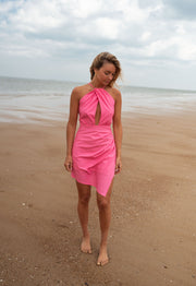 Robe asymétrique dos ouvert portée par une femme, vue de face, plage, sable