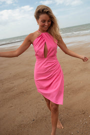 Robe asymétrique dos ouvert portée par une femme, en marchant, bras écartés, plage