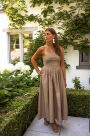 Robe effet smocké à nouer portée par une femme, vue de face, haie, mains sur les hanches