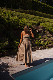 Robe effet smocké à nouer portée par une femme, vue de dos, piscine, haie