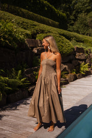 Robe effet smocké à nouer portée par une femme, vue de trois-quarts, haie, piscine