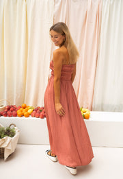 Robe bustier plissée devant portée par une femme, vue de profil, rideaux, cheveux blonds
