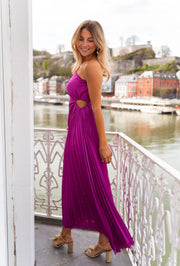 Robe plissée à taille élastique portée par une femme, vue de trois-quarts, balcon, fente