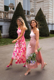 Robe plissée à ouverture latérale portée par une femme, silhouette entière, deux femmes, bouquets