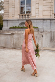 Robe plissée à ouverture latérale portée par une femme, vue de dos, bouquet, façade